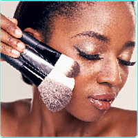 Woman applying powder concealer with a makeup brush applicator.